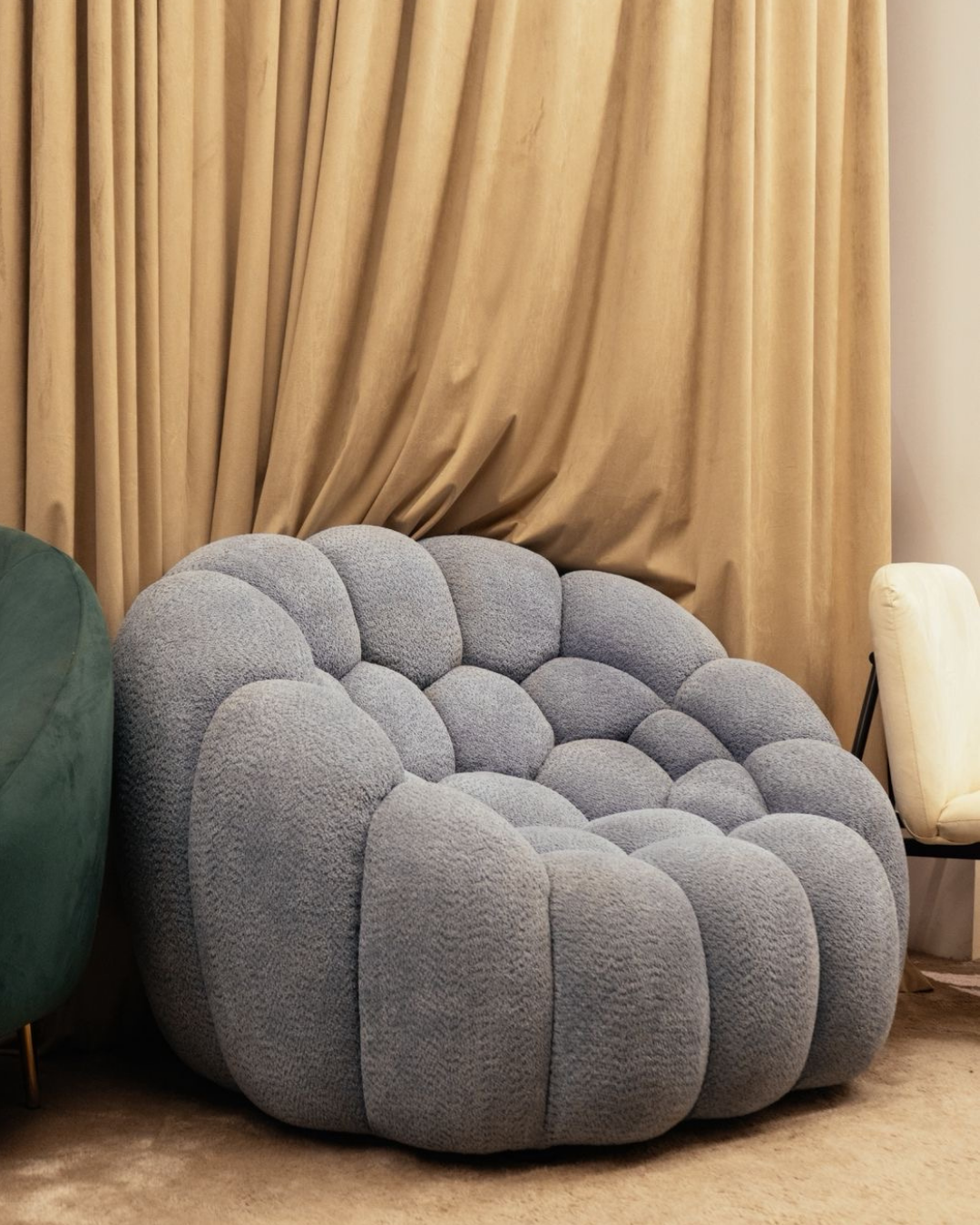 Grey bubble lounge chair with cloud-like tufted design for modern living room decor by Mahogni.