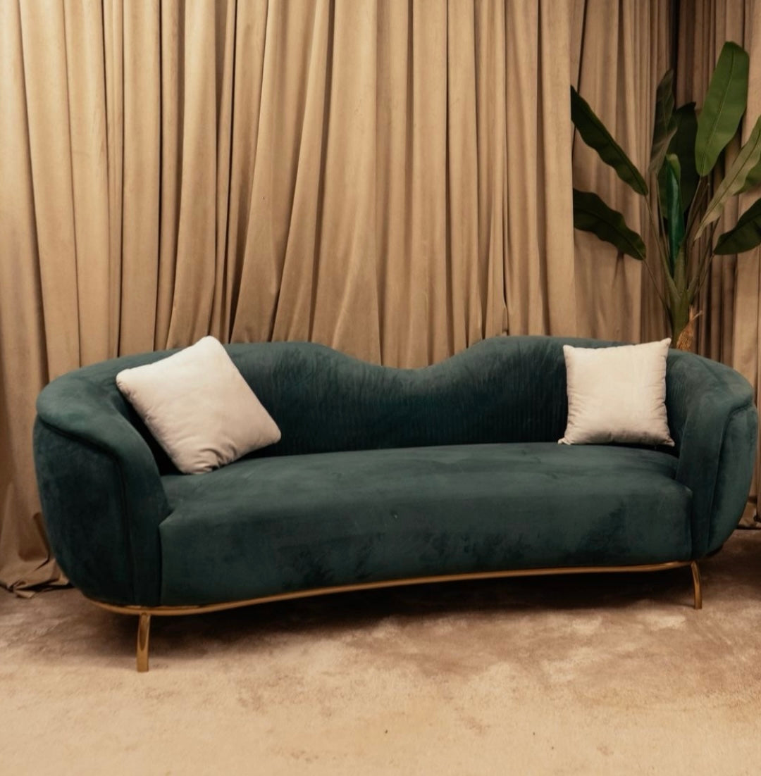 Luxury Serene curved teal velvet sofa with gold metal base and accent pillows by Mahogni furniture.