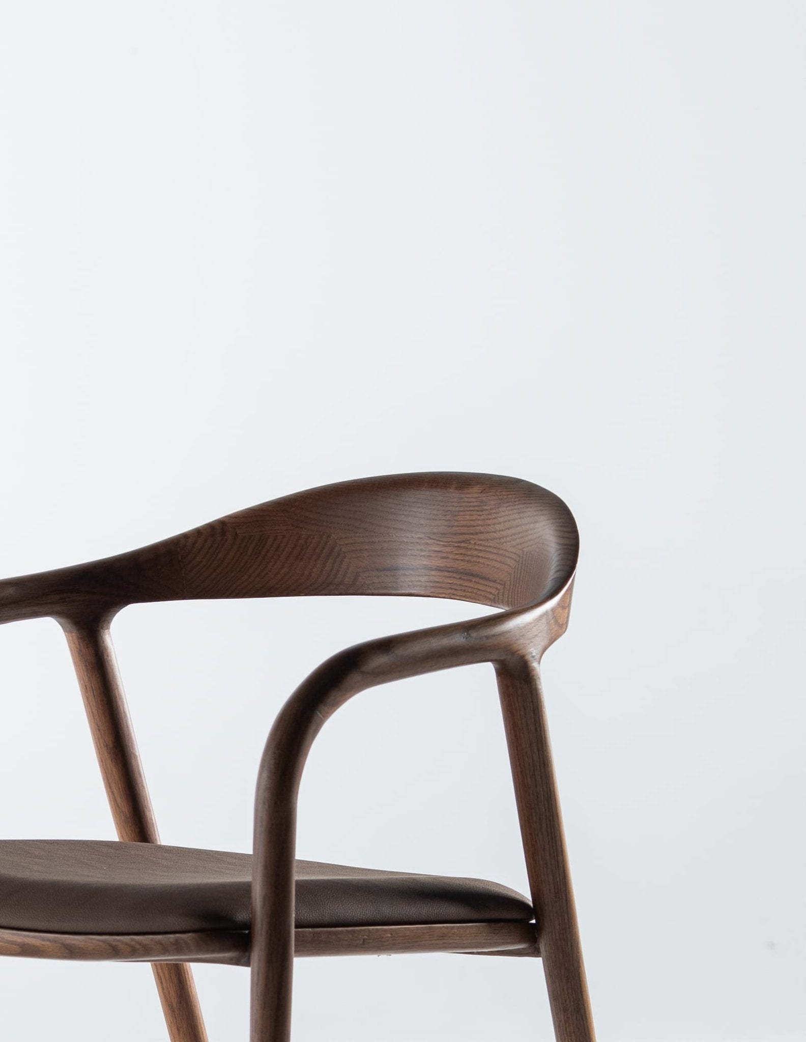 Mid-century modern brown leather dining chair with curved wooden frame by Mahogni