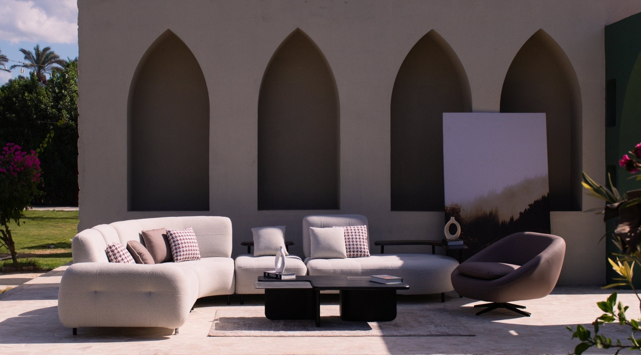 Woven Couch by Mahogni - Modern L-shaped sectional sofa in white fabric paired with a matching swivel accent chair in an architectural outdoor setting.