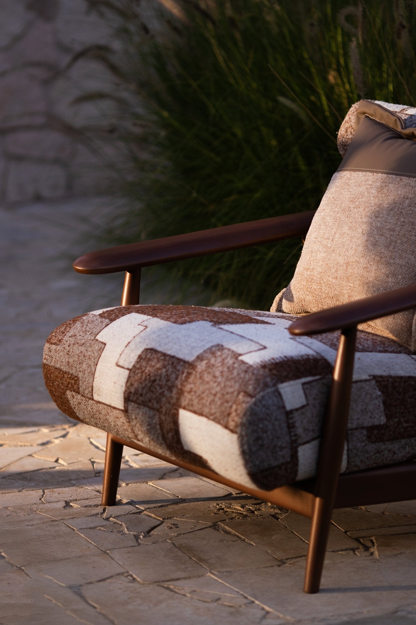 Soft living room set featuring a large modular sectional in warm beige textured fabric with geometric patterned cushions and dark wood coffee tables by Mahogni