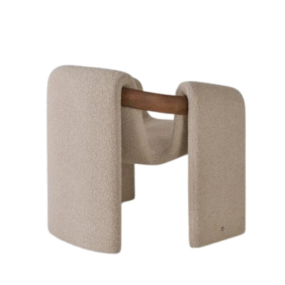 Modern sculptural fabric armchair with minimalist wooden frame design for contemporary living rooms.