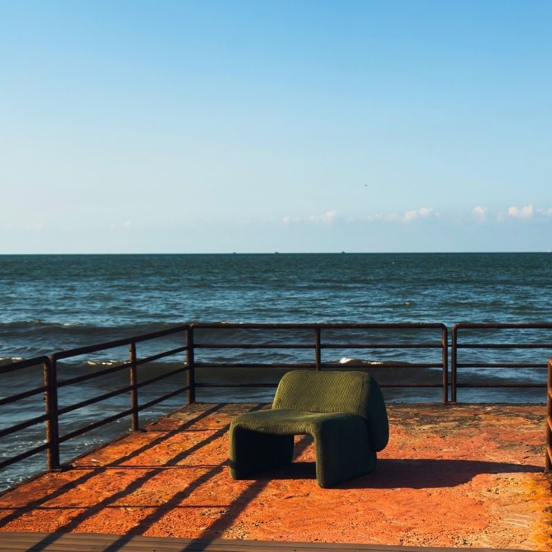 Olive green corduroy modular armchair with ribbed fabric texture on a terrace overlooking the sea Mahogni