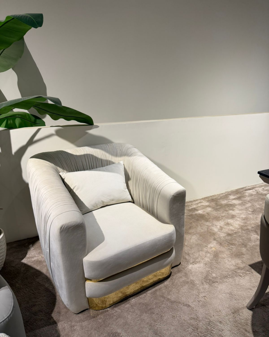 Luxury off white pleated velvet accent chair with wide gold metal base and plush pillow by Mahogni.