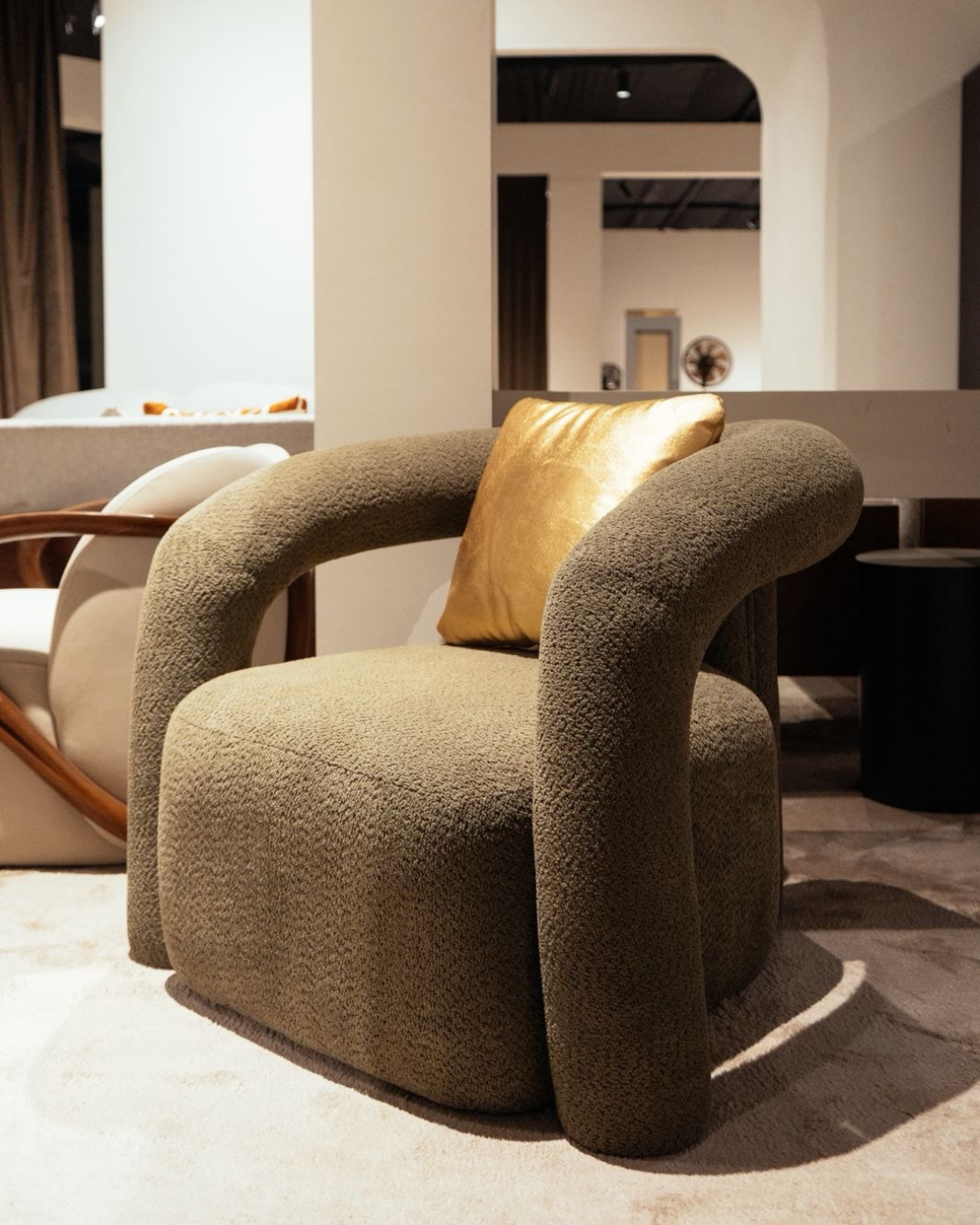 Modern aura sculptural accent chair in olive grey boucle fabric with gold satin pillow by Mahogni furniture.