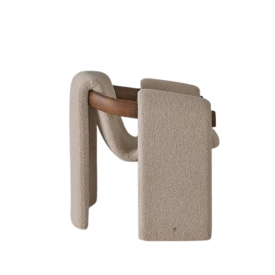 Modern sculptural fabric armchair with minimalist wooden frame design for contemporary living rooms.