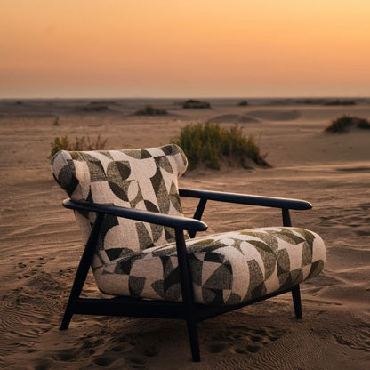Complete modular living room sofa set in pebble grey with charcoal geometric pillows on a sandy backdrop at sunset. Mahogni 