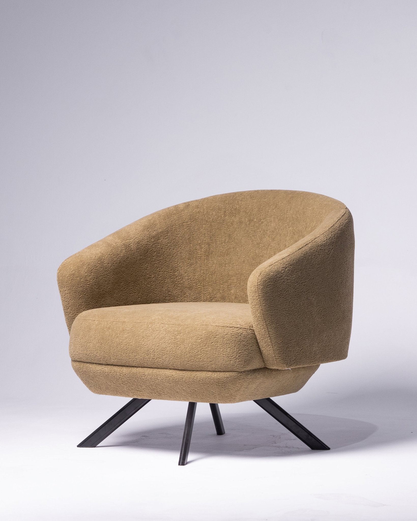 Modern tan upholstered cozy chair with black swivel base by Mahogni