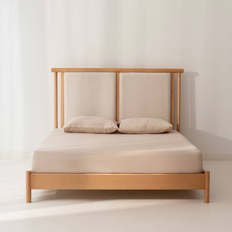 Minimalist solid oak bed frame featuring a split twin cushion upholstered headboard in beige fabric by Mahogni.