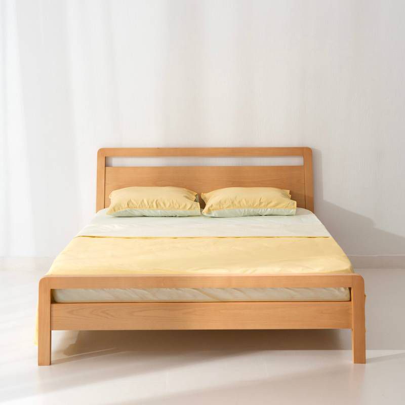 Modern solid oak wood bed frame with a sleek minimalist wooden headboard featuring a cutout design by Mahogni.