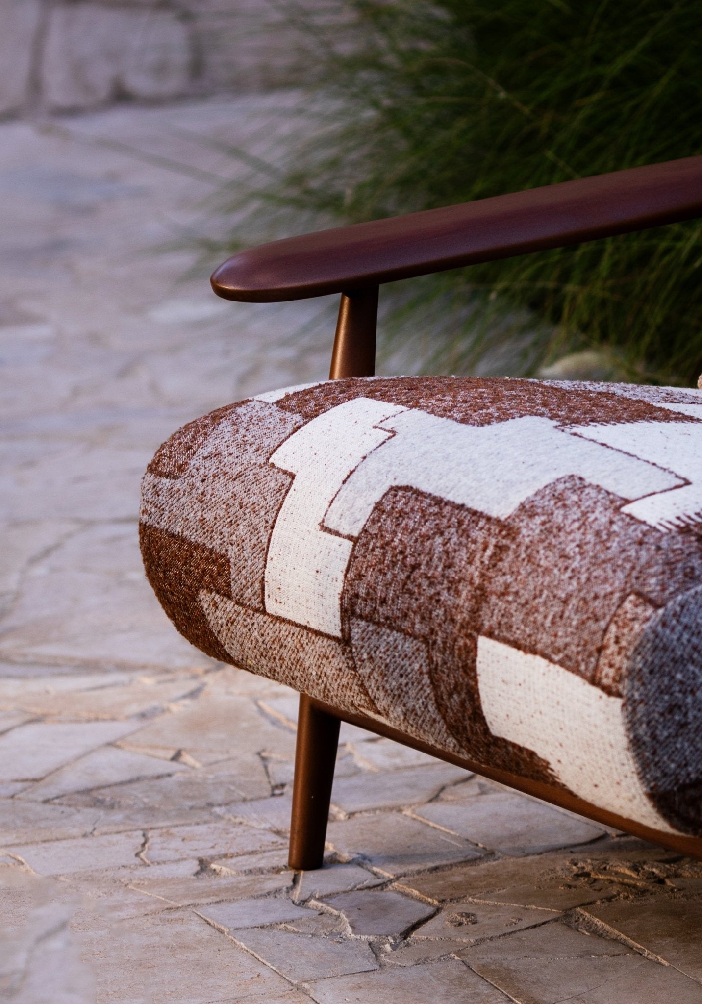 Soft living room set featuring a large modular sectional in warm beige textured fabric with geometric patterned cushions and dark wood coffee tables by Mahogni 
