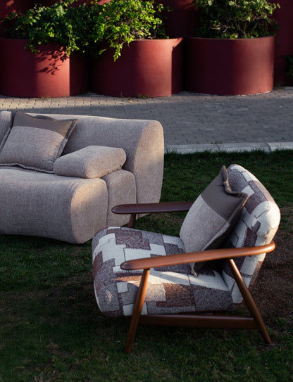Soft living room set featuring a large modular sectional in warm beige textured fabric with geometric patterned cushions and dark wood coffee tables by Mahogni 