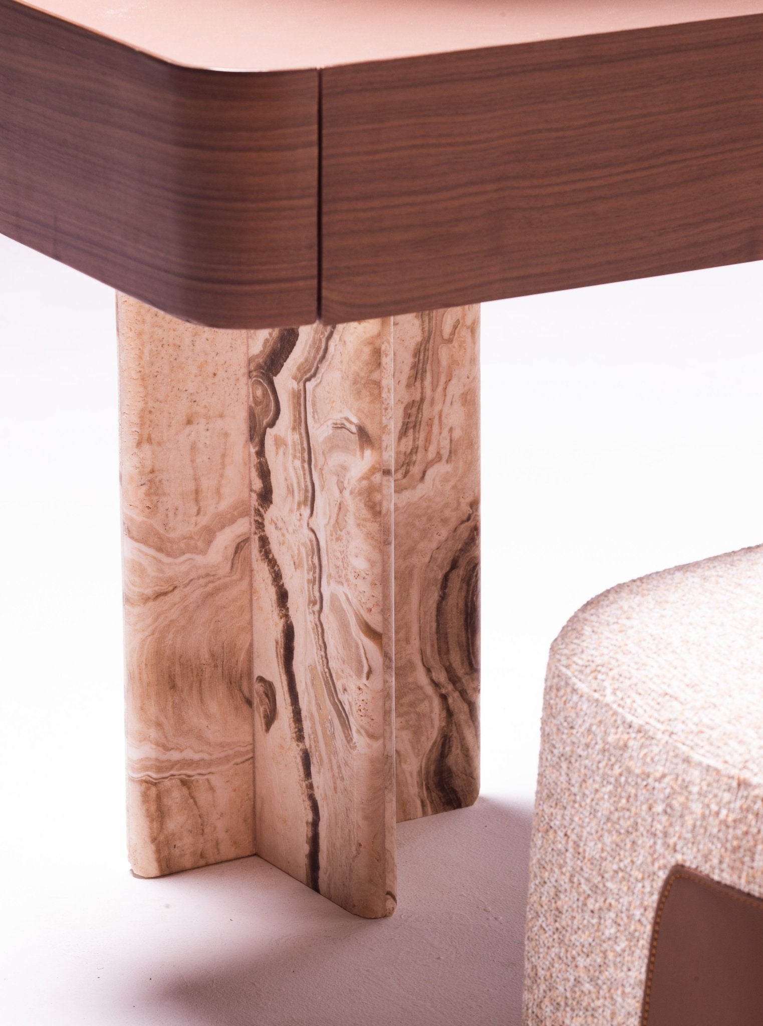 High-end luxury bedroom set featuring a tall upholstered bed with vertical tufting, dark wood nightstands, and a modern vanity by Mahogni.