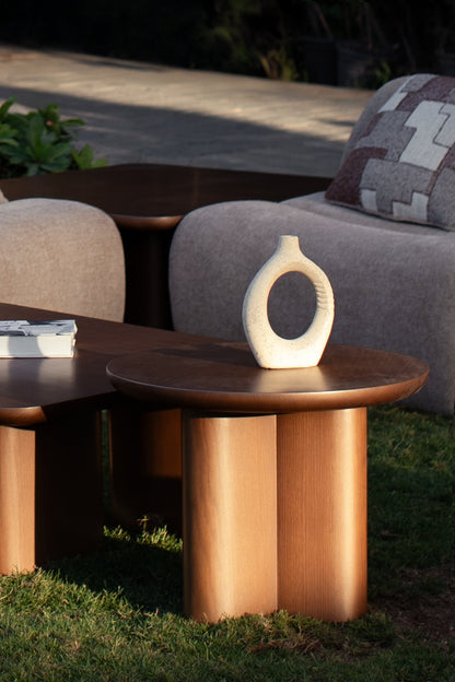 Soft living room set featuring a large modular sectional in warm beige textured fabric with geometric patterned cushions and dark wood coffee tables by Mahogni 