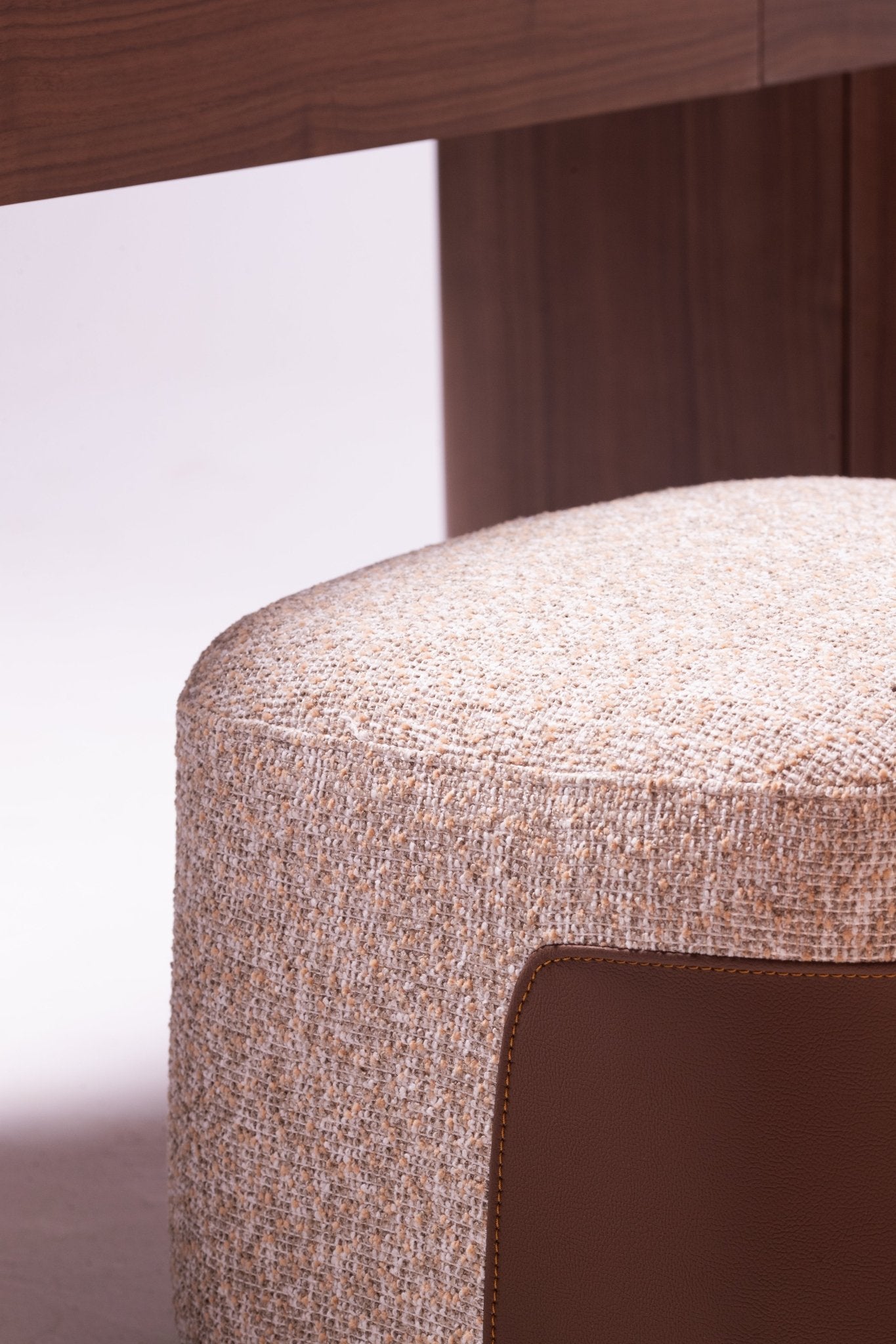 High-end luxury bedroom set featuring a tall upholstered bed with vertical tufting, dark wood nightstands, and a modern vanity by Mahogni.