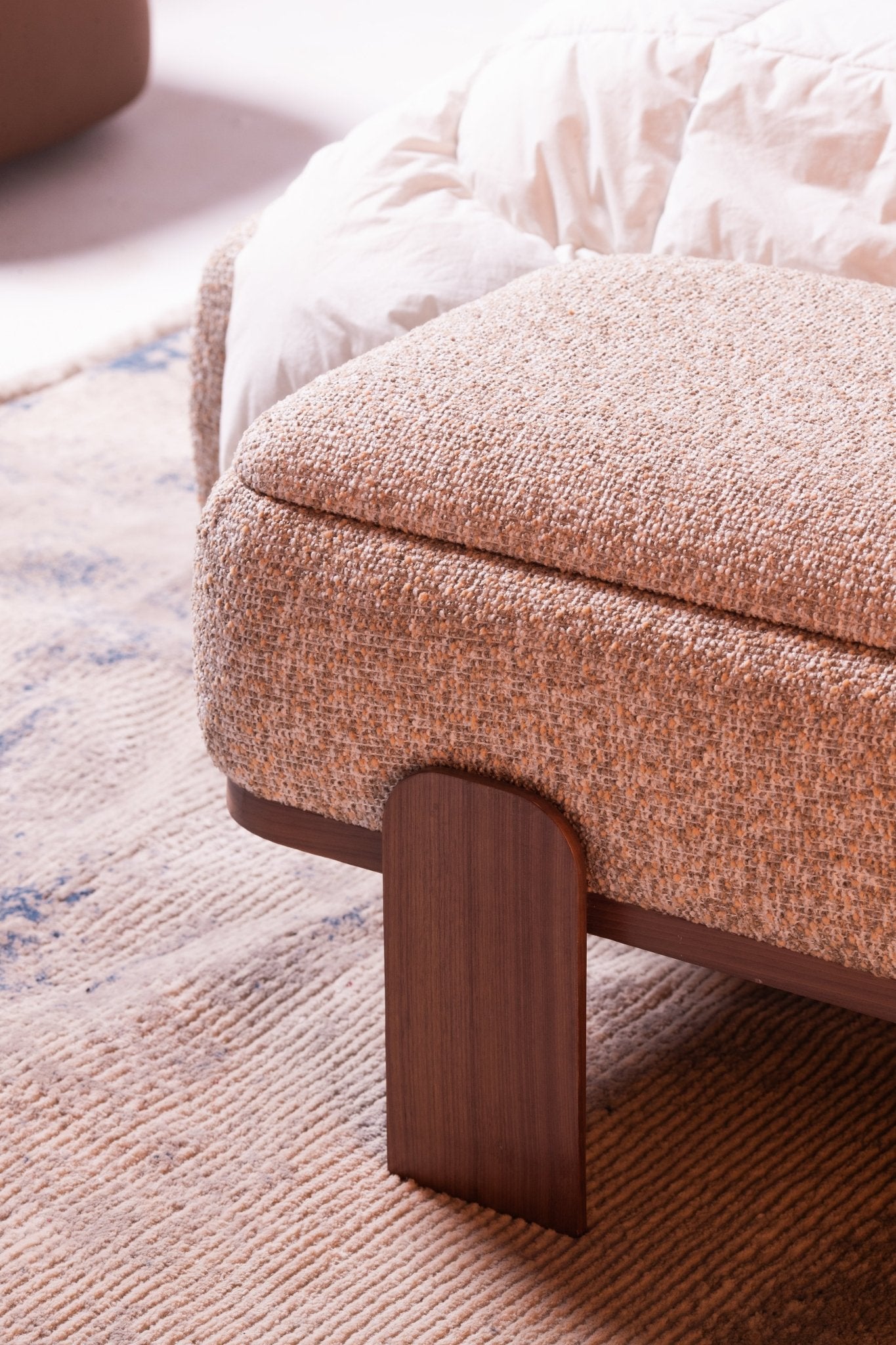 High-end luxury bedroom set featuring a tall upholstered bed with vertical tufting, dark wood nightstands, and a modern vanity by Mahogni.