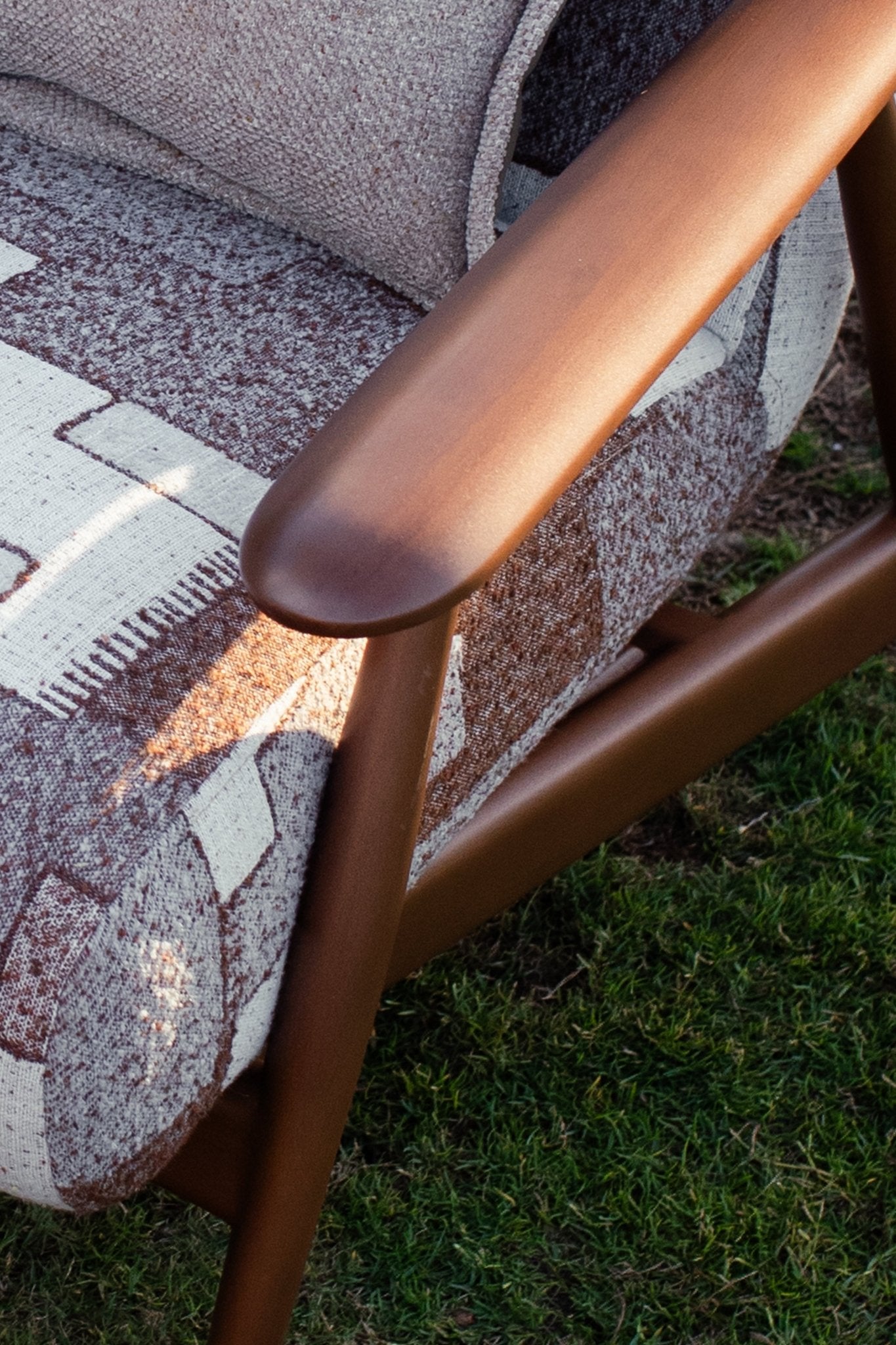 Soft living room set featuring a large modular sectional in warm beige textured fabric with geometric patterned cushions and dark wood coffee tables by Mahogni 
