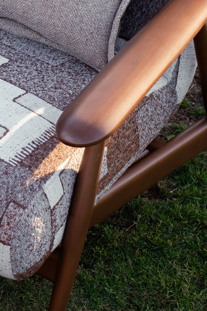 Soft living room set featuring a large modular sectional in warm beige textured fabric with geometric patterned cushions and dark wood coffee tables by Mahogni 